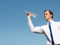 Mężczyzna z papierowym samolotem. Fot. Shutterstock