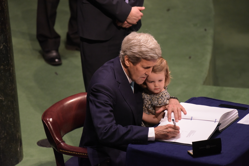 John Kerry z wnuczką na kolanach podpisuje Porozumienie Paryskie, a katz / Shutterstock.com.