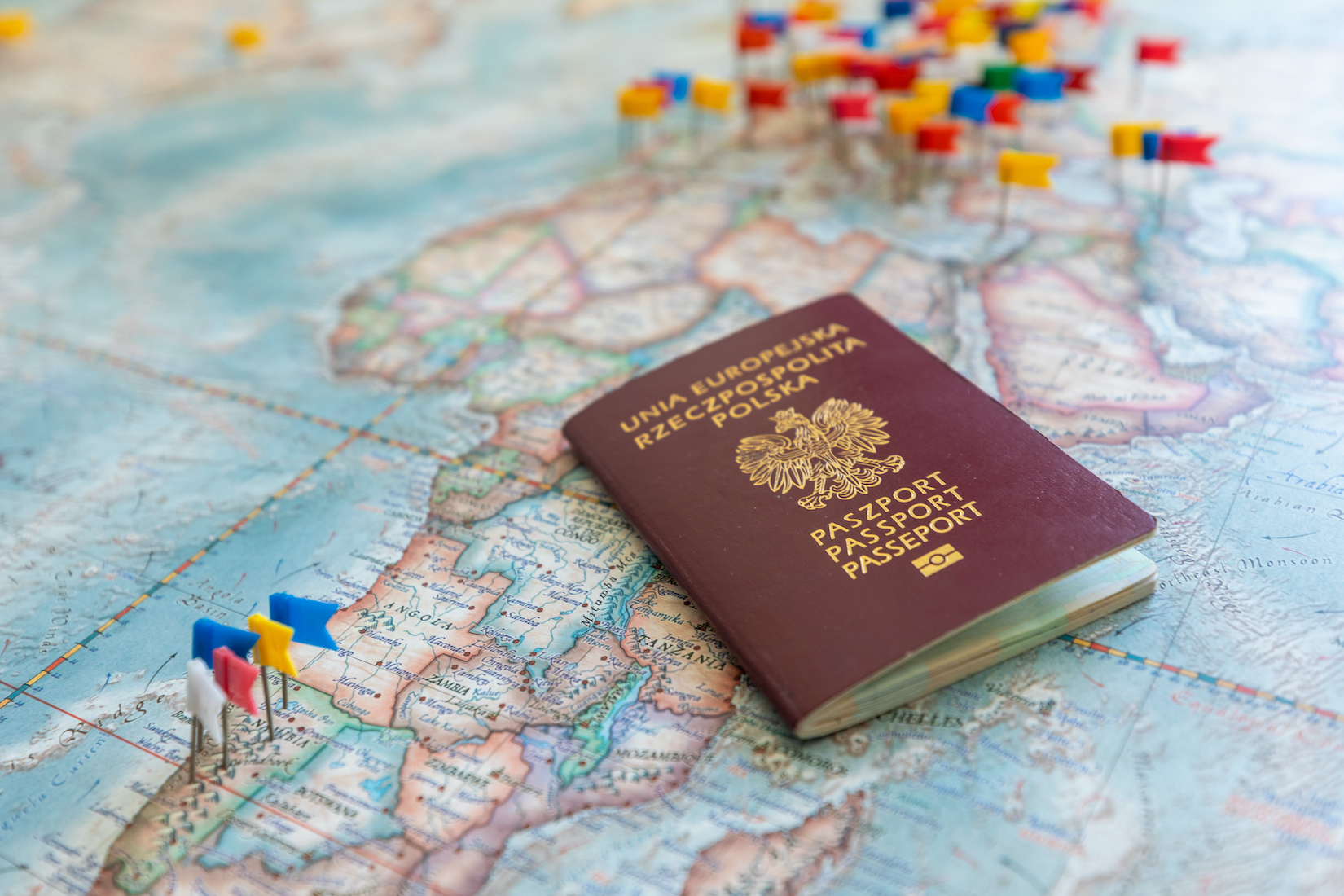 Polski paszport na tle mapy, fot. Tomasz Wozniak / Shutterstock.com