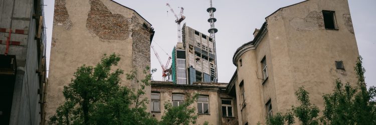 Nierówności w Warszawie: nowoczesny wieżowiec i rozpadająca się kamienica. Fot. Shutterstock
