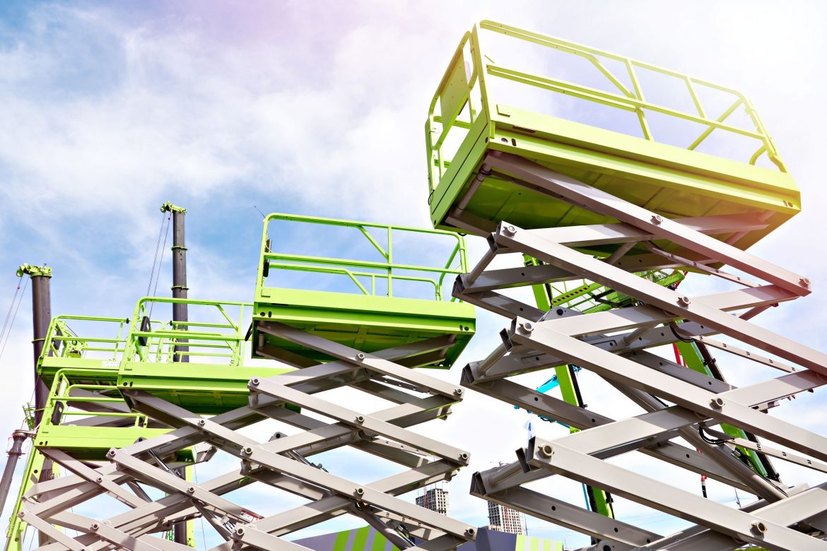 Trzy zielone podnośniki nożycowe