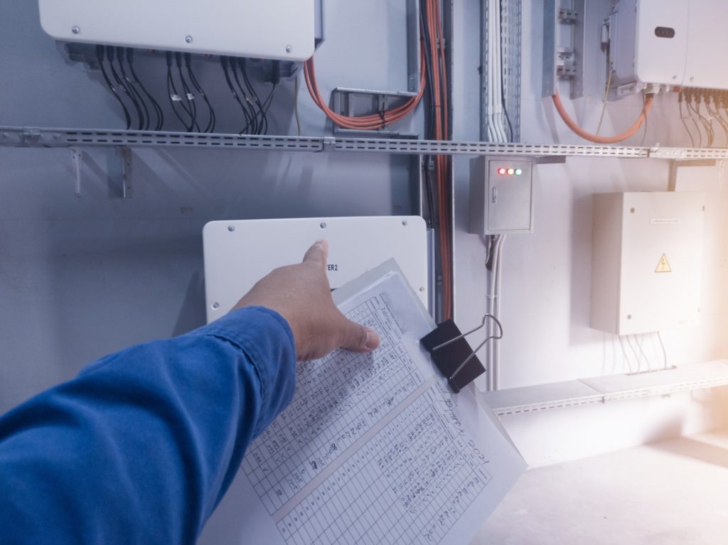 	Specjaliści omawiający wyniki audytu energetycznego firmy przy dokumentacji technicznej