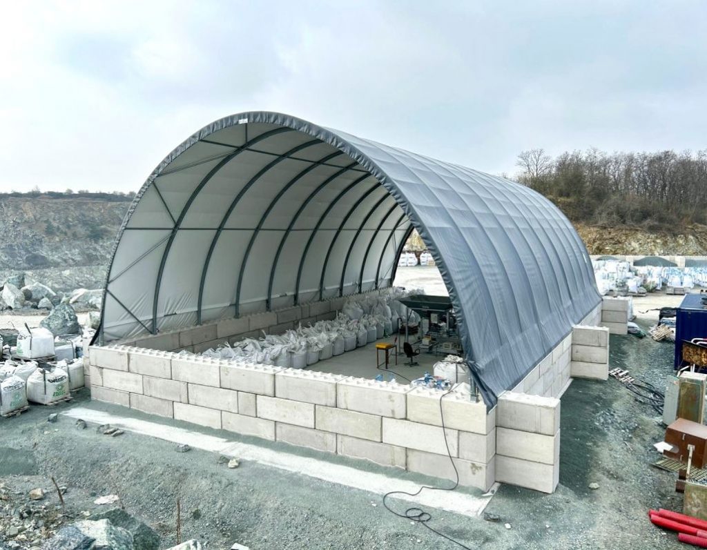 Hala namiotowa na blokach betonowych wykorzystywana do składowania materiałów